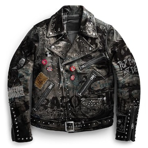 May include: A black leather jacket with a silver studded design. The jacket has a variety of patches and pins, including a leopard print patch, a red and white pin with the text "Pop Punk Not Dead", and a black and white pin with the text "Gator Dundas".
