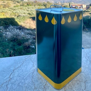 May include: A green metal can with a yellow band around the top and bottom. The can has a silver handle and five yellow oil drop designs on the front.