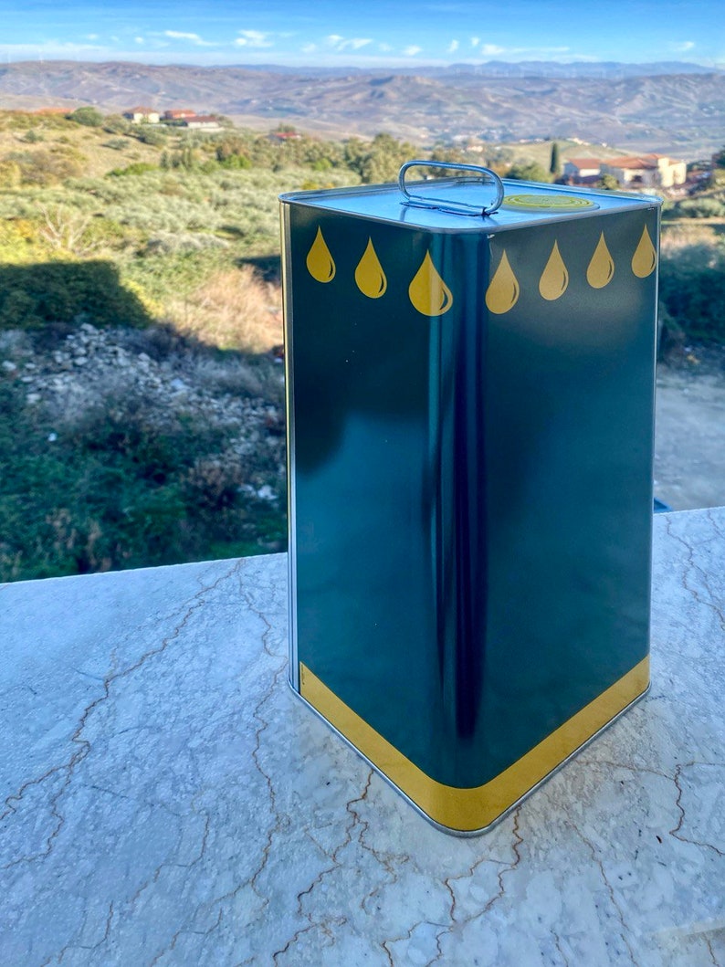 May include: A green metal can with a yellow band around the top and bottom. The can has a silver handle and five yellow oil drop designs on the front.