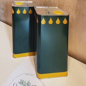 May include: Two green metal olive oil cans with yellow lids and yellow oil drop designs. The cans are sitting on a white surface with a circular logo that says "OLIVE" in green.