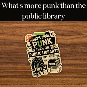 May include: A sticker with the text "What's more punk than the public library?" features a skull, anarchy symbol, and a studded jacket. The sticker is on a wooden surface.