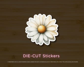 Puede incluir: Una pegatina troquelada con una margarita blanca con centro amarillo. La margarita tiene múltiples pétalos y está sobre un fondo de madera marrón oscuro. El texto "DIE-CUT Stickers" se muestra en la parte inferior.