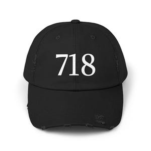May include: Black distressed baseball cap with the white number 718 on the front. The cap has a curved brim and a distressed, worn look.