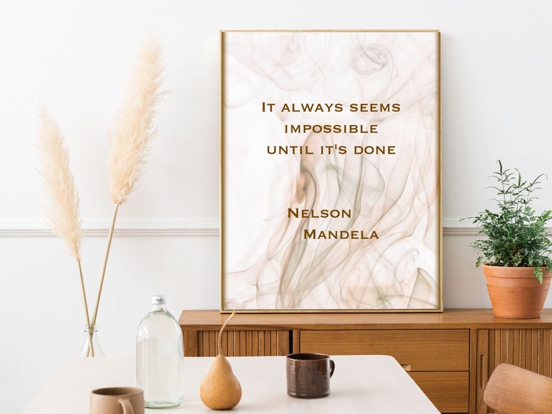 May include: A motivational quote by Nelson Mandela printed on a beige and white abstract art print. The quote reads "It always seems impossible until it's done."