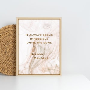May include: A framed print with a quote by Nelson Mandela: "It always seems impossible until it's done." The background is a soft, abstract design in shades of beige and white.