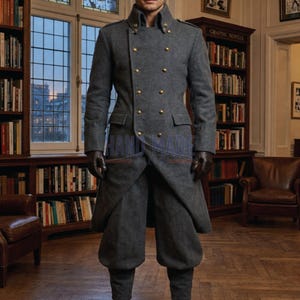 May include: A gray wool coat with gold buttons and a double-breasted design. The coat has a high collar and is paired with matching gray pants. The outfit is completed with dark gloves. The coat is a classic style.