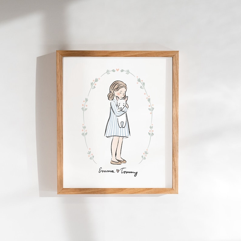 Peut inclure: Une illustration encadr&eacute;e d'une fille en robe ray&eacute;e bleu et blanc tenant un chien blanc. L'illustration est entour&eacute;e d'une couronne de feuilles vertes et de fleurs roses. Le texte "Emma &hearts; Tommy" est &eacute;crit sous l'illustration.
