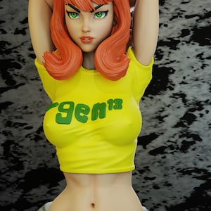 May include: A woman with red hair and green eyes is wearing a yellow crop top with the word "gem13" printed on it. She is wearing sunglasses and has her arms raised above her head.
