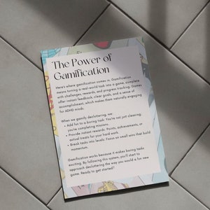 May include: A rectangular card with the title "The Power of Gamification" and explanatory text. The card has a light background with colorful floral-like designs around the edges. The text describes how to make tasks more engaging.