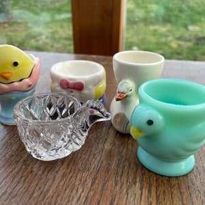 A collection of vintage egg cups including Opalex and cut glass