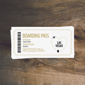 K&ouml;nnte beinhalten: Eine wei&szlig;e Bordkarte mit goldener Schrift, auf der "Boarding Pass" steht. Der Name des Passagiers ist Joanne Parker und das Abflugdatum ist der 02/09/24. Der Text "Happy 50th Birthday! I hope you have an amazing day. Love Daniel x" ist unter dem Abflugdatum gedruckt. Ein goldenes Herz mit einer gestrichelten Linie darum herum und dem Text "Las Vegas" darin befindet sich in der oberen rechten Ecke der Karte.
