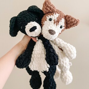 Pu&ograve; includere: Due giocattoli di peluche a forma di cane realizzati a uncinetto. Uno &egrave; bianco e nero, l'altro &egrave; marrone e bianco.
