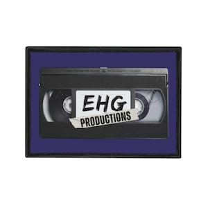 May include: A black VHS tape patch with the text "EHG PRODUCTIONS" on a white label. The patch is set against a dark blue background with a black border.