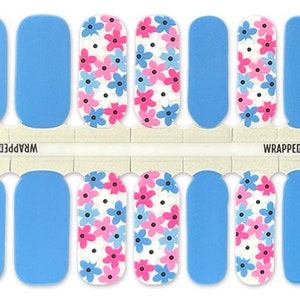 May include: A set of 10 nail wraps featuring a blue background with a white and pink floral pattern. The nail wraps are labeled "Wrapped Up Polish".