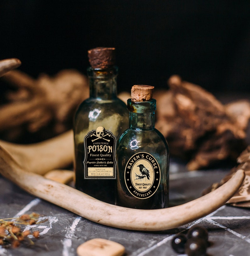 Puede incluir: Dos botellas de boticario antiguas de vidrio con tapones de corcho. Una botella tiene una etiqueta que dice "UNFILTERED POISON, Finest Quality". La otra botella tiene una etiqueta que dice "RAVEN'S CURSE, Finest Quality, Apothecary".