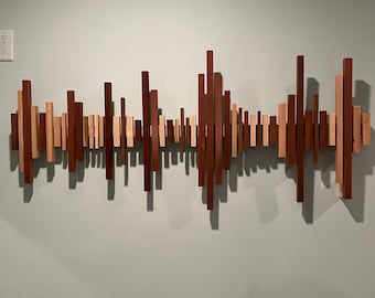 May include: A wall art piece made of various wooden blocks of different sizes and shades of brown, arranged in a wave-like pattern.