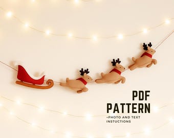May include: A festive Christmas garland featuring a red sleigh and three reindeer with red scarves and black antlers. The garland is strung on a thin string, with the text "PDF PATTERN" and "+PHOTO AND TEXT INSTRUCTIONS" in black.