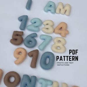 May include: A collection of felt numbers and letters in shades of blue, beige, and brown. The image shows the numbers 1 to 10, the letters "I AM", and the words "PDF PATTERN".