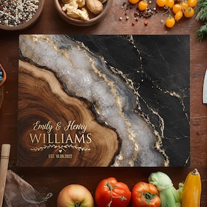 May include: A rectangular chopping board with a distinctive design. It features wood grain, marble, and gold accents. The text "Emily & Henry WILLIAMS" and the date "EST. 10.09.2022" are displayed on the board.