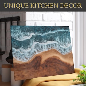 May include: Wooden rectangular chopping board with an ocean wave design. The top half has a teal and white wave pattern, and the bottom half is natural wood grain. The text "UNIQUE KITCHEN DECOR" is at the top.