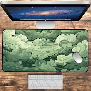 May include: Green and white abstract cloud design mouse mat. The mouse mat has a dark green background with swirling white clouds.