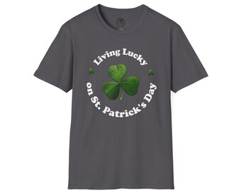 May include: A dark gray t-shirt with a white circle graphic that says "Living Lucky on St. Patrick's Day" with a green shamrock in the center.