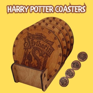 May include: Set of six wooden Harry Potter coasters featuring the Slytherin house crest. The coasters are stacked in a wooden holder. Each coaster has the Harry Potter logo and the house crest.