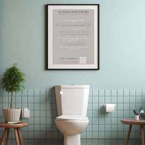 May include: A framed print with a light grey background and white text. The text reads "No phone on the throne?" and includes a series of questions and a QR code. The print is hanging on a light blue tiled wall in a bathroom.