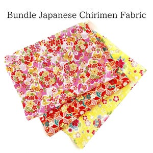 以下が含まれることがあります： 3枚の日本の縮緬生地の正方形の束。生地は柔らかくしわのある絹で、花柄です。正方形はピンク、黄色、赤の色合いです。