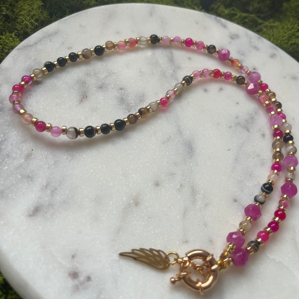 Necklace with pink colour finish it with gold . handmade natural stone.with wings charm gold finish.