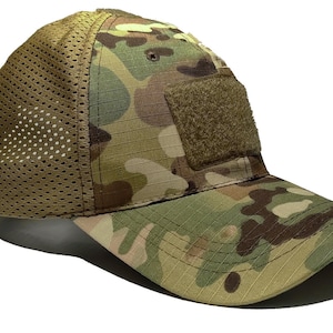 Puede incluir: Una gorra de béisbol de camuflaje con un panel trasero de malla y un parche de velcro en la parte delantera. La gorra está hecha de una tela ligera y transpirable.