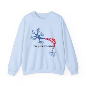 May include: Light blue sweatshirt with a graphic of a neuron and the text "I've got pOtential".