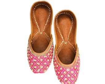 May include: A pair of pink embroidered flat shoes with gold sequins. The shoes have a pointed toe and a low heel.