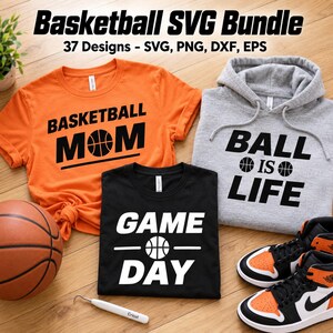 Könnte beinhalten: Ein orangefarbenes T-Shirt mit schwarzem Text BASKETBALL MOM, ein schwarzes T-Shirt mit weißem Text GAME DAY und ein grauer Kapuzenpullover mit schwarzem Text BALL IS LIFE. Ein Basketball und ein weißes Entgitterungswerkzeug sind sichtbar.