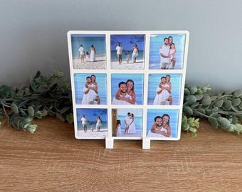 May include: A white square photo display frame featuring a grid of nine individual square photo slots. Each slot contains a photograph of people dressed in white clothing on a beach. The frame has a clean, minimalist border and a stand.