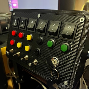 May include: A black panel with four toggle switches, nine buttons, and three toggle switches. The panel has a carbon fiber pattern and is mounted on a black metal stand. The panel has a key lock on the right side.