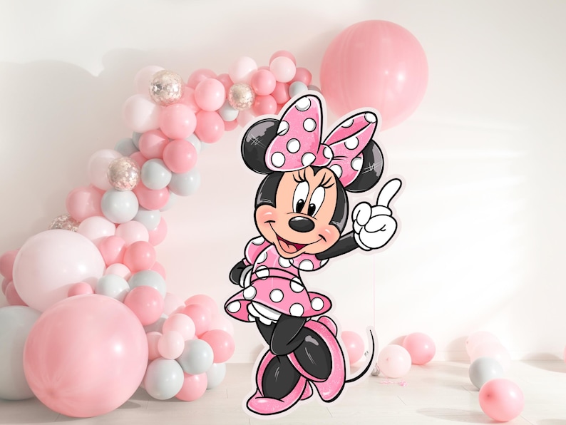 K&ouml;nnte beinhalten: Ein rosa-wei&szlig;es Minnie Mouse-Charakter-Ausschnitt mit einer rosa Schleife und wei&szlig;en Punkten. Der Charakter steht vor einem Ballonbogen aus rosa, wei&szlig;en und silbernen Ballons.