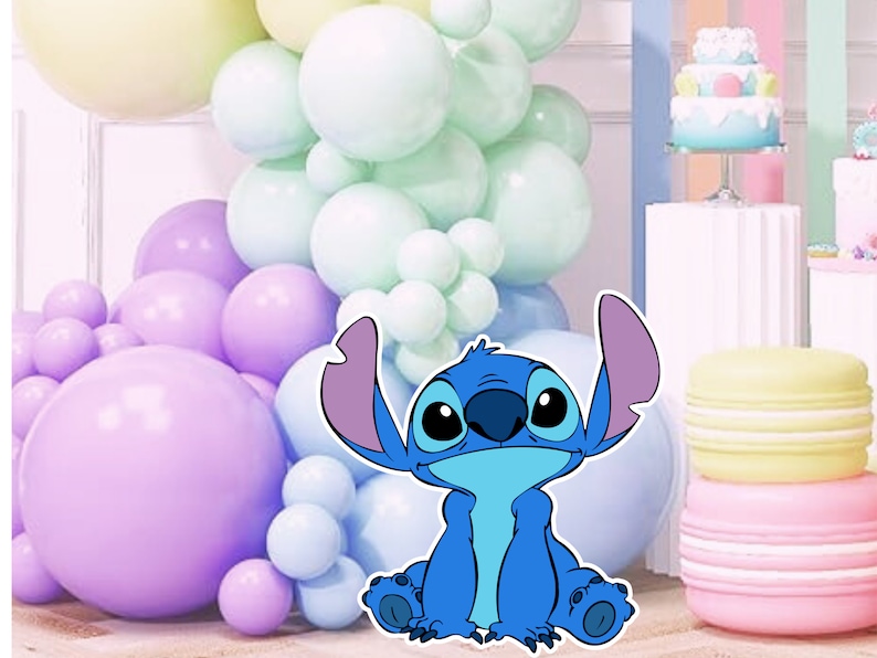 May include: A blue cartoon character with large ears and a big smile, sitting in front of a backdrop of pastel colored balloons.