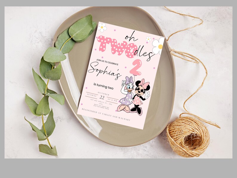 May include: A pink birthday invitation with the text "oh Twodles" and "Sophia's is turning two." Features Daisy Duck and Minnie Mouse. The invitation is on a grey plate with greenery and twine.
