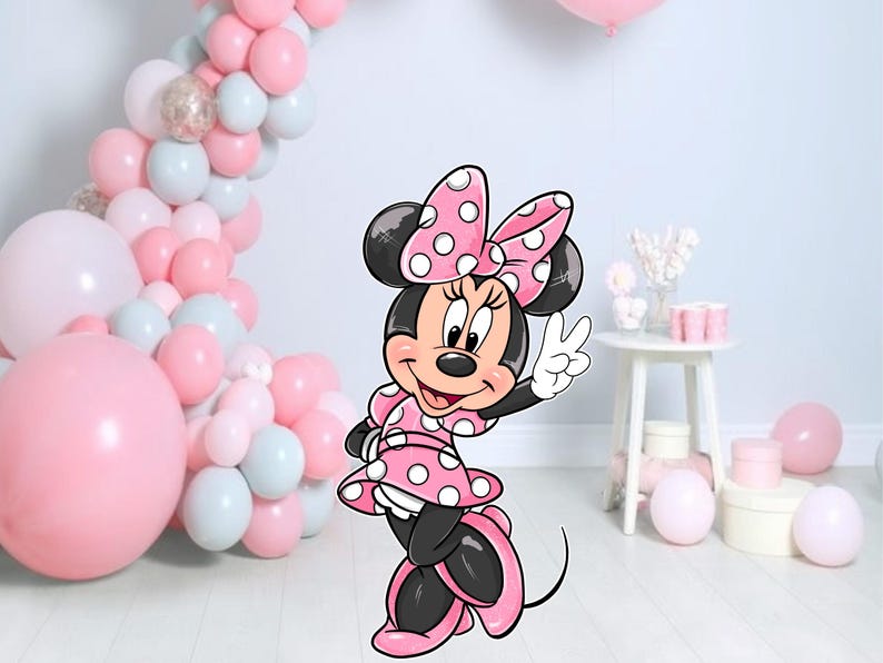 Op de afbeelding: Een cartoon illustratie van Minnie Mouse in een roze polkadot jurk en strik, die een vredesteken geeft. De achtergrond toont een ballonnenboog in roze, witte en zilveren tinten, met extra roze ballonnen en feestversieringen.