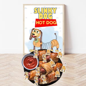 Può includere: Una stampa incorniciata con le parole "Slinky Dog Hot Dog" e un'illustrazione del personaggio Slinky Dog. Un piatto di pasticcini per hot dog e una ciotola di salsa rossa sono davanti alla stampa. Lo sfondo è azzurro e bianco.