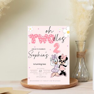 May include: A pink birthday invitation with the text "oh TWOdles" and "Sophia's is turning two." Features Daisy Duck and Minnie Mouse. Includes date and time details. Decorated with flowers and a pink balloon.