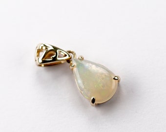 Op de afbeelding: Een gouden hanger met een peervormige opaal edelsteen. De hanger heeft een delicaat, ingewikkeld ontwerp.