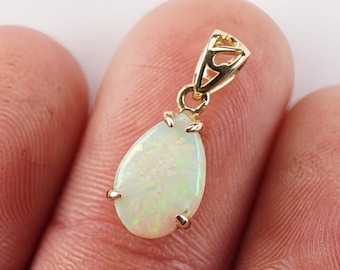 Op de afbeelding: Een gouden hanger met een traanvormige opaal edelsteen. De hanger heeft een delicate, sierlijke bail.