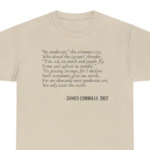 Op de afbeelding: Een beige t-shirt met een citaat van James Connolly uit 1907. Het citaat luidt: "Wees gematigd", roepen de trimmers... We willen alleen de aarde." De tekst is donkergrijs.