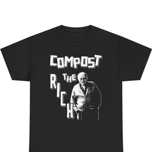 May include: Black t-shirt featuring the text "COMPOST THE RICH" in white, bold lettering, alongside an image of a man. The man is wearing a cardigan. The graphic design is simple and striking.