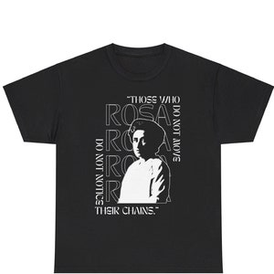 Puede incluir: Camiseta negra con un gráfico blanco de Rosa Parks y la cita "Aquellos que no se mueven no notan sus cadenas."