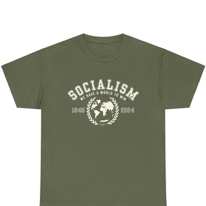 May include: A green t-shirt with a white graphic that says "Socialism We Have A World To Win 1949 2024" with a globe and laurel wreath.