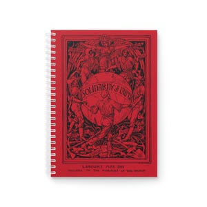 May include: Red spiral notebook with a black and white illustration of people holding a globe with the text "Solidarity of Labour" and the words "Labour's May Day Dedicated to the Workers of the World".