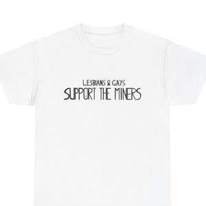 May include: White t-shirt with the text "LESBIANS & GAYS SUPPORT THE MINERS" in black, centered on the front. The shirt has a crew neck and short sleeves. The text is in a bold, sans-serif font.